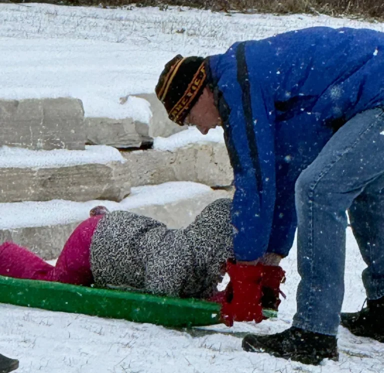 A man playing with a small child on a snowy day in Illinois