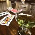 Glass of green charteuse and game of Kings Corners