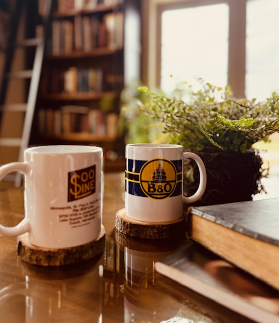 Two coffee cups, a journal and a Bible on a table in a library. Featured in Anchors not Chains: Building a Home Rhythm