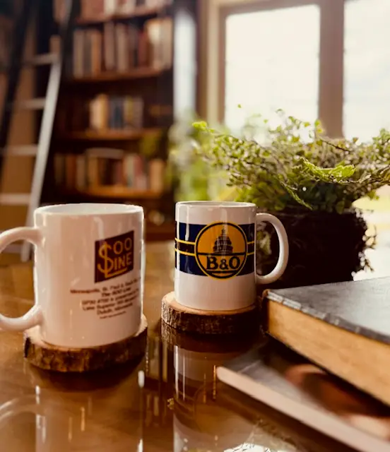 Two coffee cups, a journal and a Bible on a table in a library. Featured in Anchors not Chains: Building a Home Rhythm