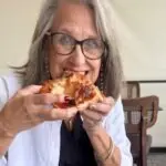 Lady eating a piece of pizza in Parma
