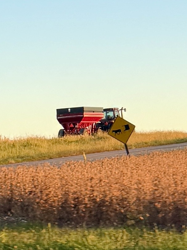 Tractor and grain trailer behind an Amish traveling road sign in Three Weekends, Three Trips, One Car